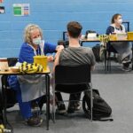 Um estudante recebe uma vacina no pavilhão esportivo da Universidade de Kent, em Canterbury, após um surto anterior
