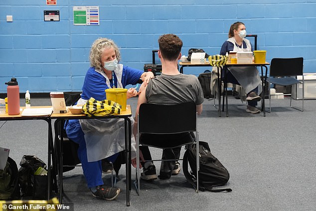 Um estudante recebe uma vacina no pavilhão esportivo da Universidade de Kent, em Canterbury, após um surto anterior