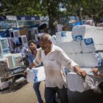 epa12936244 Um trabalhador indiano descansa em um andaime enquanto um táxi passa perto de um mercado durante uma tarde quente em Calcutá, Índia, 6 de maio de 2026. O Departamento Meteorológico da Índia (IMD) previu que as temperaturas atingirão até 38 graus Celsius à medida que uma onda de calor persiste em Bengala Ocidental. EPA/PIYAL ADHIKARY