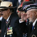 Veterans salute in the amphitheatre at the Tomb of the Unknown Soldier at the start of a ceremony in Arlington National Cemetery in Arlington, Virginia, on Memorial Day, May 26, 2025. (Photo by Brendan SMIALOWSKI / AFP) (Photo by BRENDAN SMIALOWSKI/AFP via Getty Images)