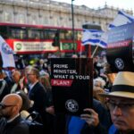 Um homem passa por um veículo de investigação e fiscalização do conselho em Londres, quinta-feira, 30 de abril de 2026, perto do local onde duas pessoas foram recentemente esfaqueadas no bairro Golders Green, que possui uma grande comunidade judaica. (Foto AP/Alastair Grant)