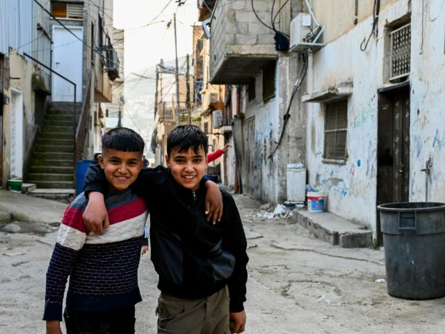 Uma trilha cercada por árvores no campo de refugiados de Tel Askar
