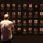 Pessoas em Tel Aviv passam por um muro com fotos de reféns detidos na Faixa de Gaza em janeiro de 2024.