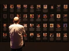 ‘Sistemático, generalizado e integral’: novo relatório expõe todo o horror do ataque liderado pelo Hamas Pessoas em Tel Aviv passam por um muro com fotos de reféns detidos na Faixa de Gaza em janeiro de 2024.