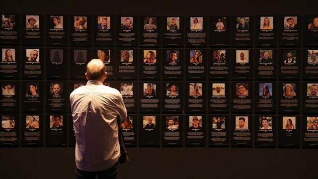 Pessoas em Tel Aviv passam por um muro com fotos de reféns detidos na Faixa de Gaza em janeiro de 2024.