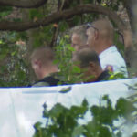 WJLA - FOTO: Um policial do estado de Maryland, em 21 de junho de 2026, perto do local dos destroços de um pequeno avião que caiu e matou três pessoas a bordo em Bowie, Maryland.