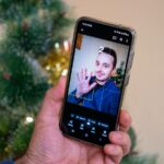 Um smartphone em um fundo colorido com o ícone do app da câmera Google Pixel na tela, sobreposto por um círculo vermelho com uma cruz