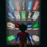 60% dos vídeos do TikTok são resíduos de IA; 21% dos do YouTube | A imagem mostra um personagem robô de brinquedo em frente a um conjunto desfocado de ícones de aplicativos