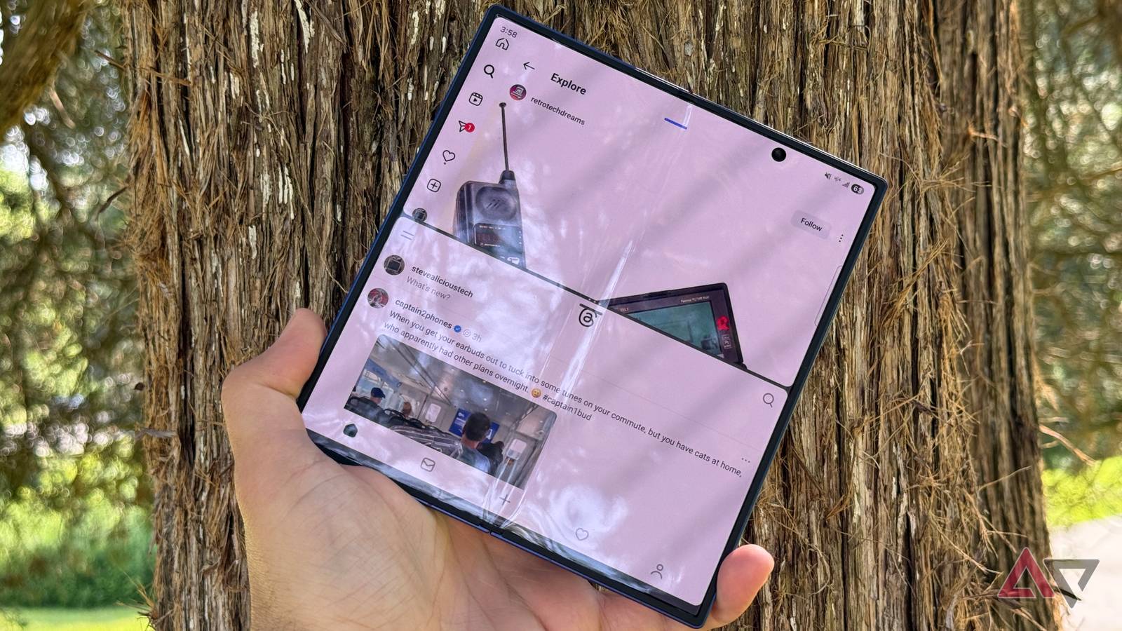 Mãos segurando um Samsung Galaxy Z Fold 8 Wide em um fundo azul.