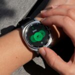 Imagem teaser escura do Samsung Galaxy Watch Series, mostrando três silhuetas de smartwatch com bordas brilhantes em um fundo azul.
