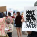 Manifestantes seguram cartazes durante um protesto contra o data center do Projeto Azul em Tucson, Arizona