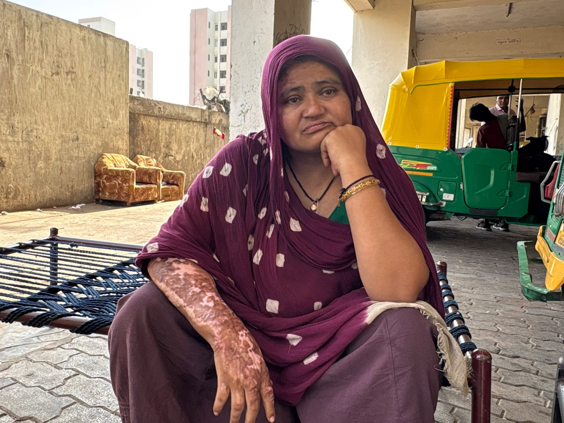 Sita Patni acende uma lamparina a óleo em frente às fotos de seu filho Aakash, morto quando o avião caiu perto de sua barraca de chá em Ahmedabad, Índia (Marhaba Hilali/Al Jazeera)