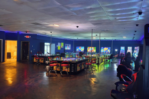 Interior do local de jogos ilegais 999 Arcade em Charlotte, Carolina do Norte, mostrando fileiras de máquinas de jogos, estações de jogos, iluminação neon e áreas de estar durante uma investigação do CMPD sobre operações ilegais de jogos de azar.
