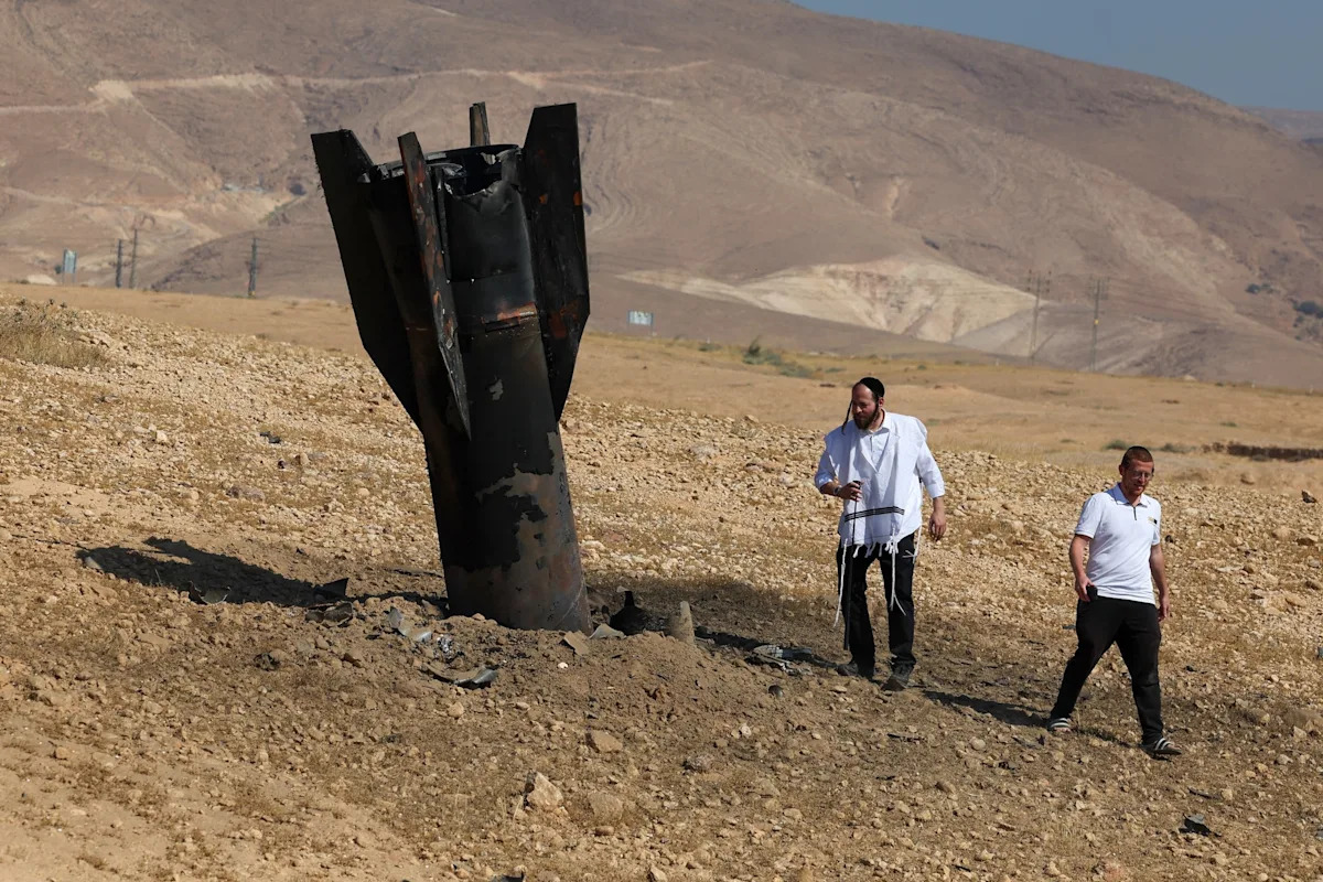 Foto de Ghaith Alsayed / AP - FOTO: Agricultores borrifam água em um campo agrícola queimado próximo a um projétil perto da cidade de Najha, Síria, 8 de junho de 2026, depois que destroços de lançamentos de mísseis iranianos durante o conflito Irã-Israel caíram na área.