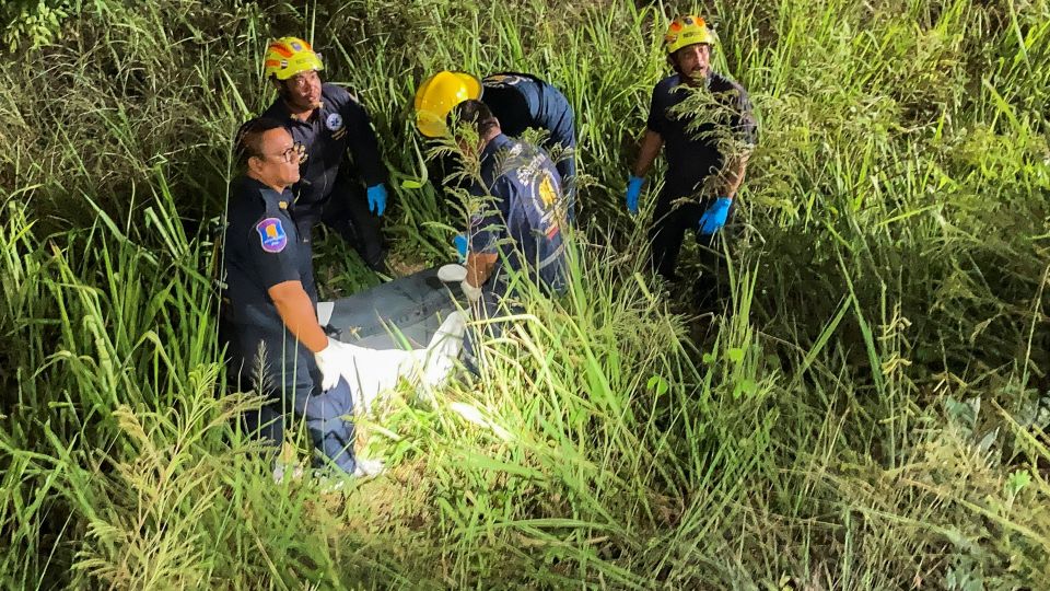 Equipes de resgate, policiais e técnicos forenses vasculham uma área gramada perto de uma ferrovia antes que a polícia encontre uma mala contendo o corpo de uma menina tailandesa de 17 anos na cidade de Pattaya, em 27 de junho. - Teerasak Suttativong/Reuters