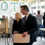With ballot in hand, California Governor Gavin Newsom walks to a voting booth in Sacramento on November 8, 2022.