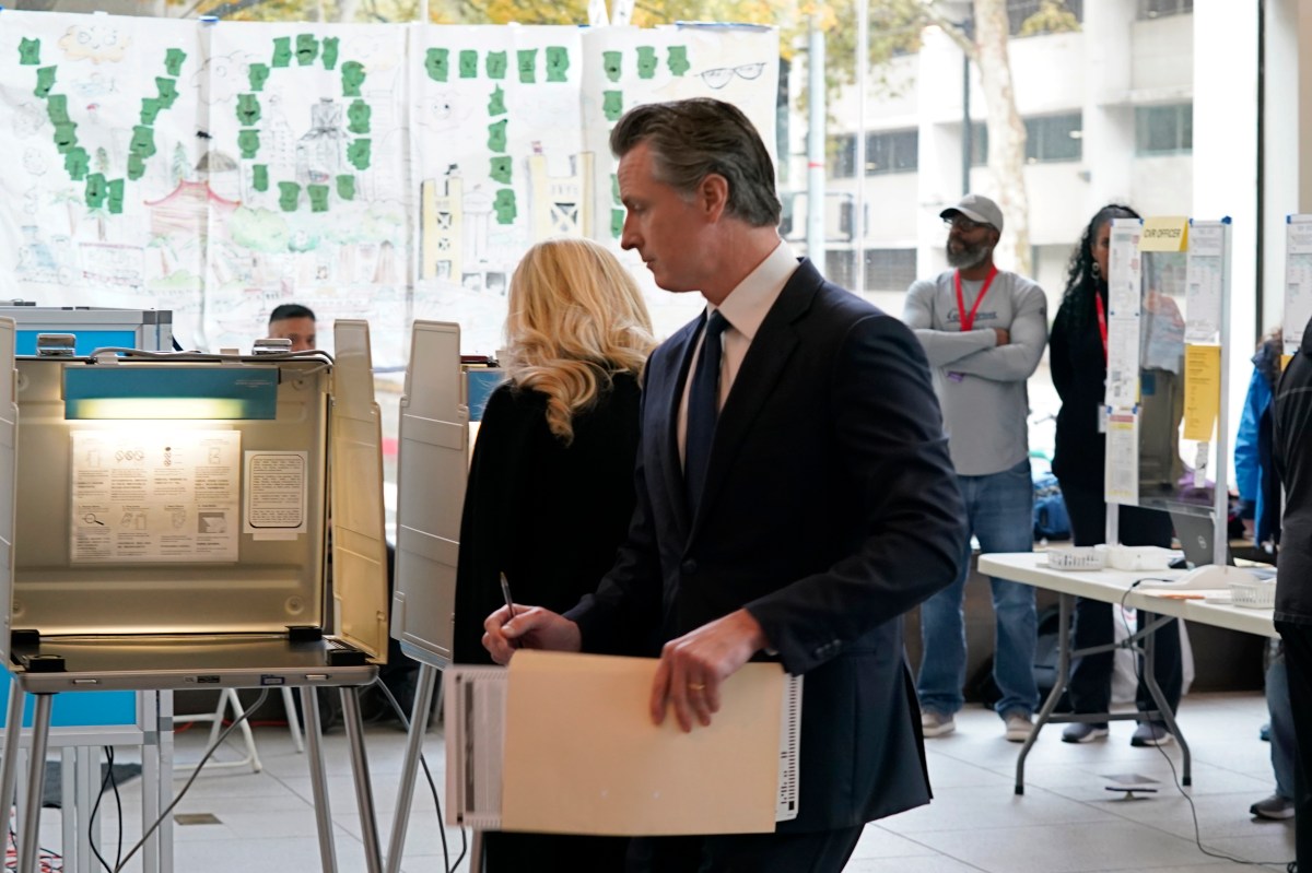 With ballot in hand, California Governor Gavin Newsom walks to a voting booth in Sacramento on November 8, 2022.