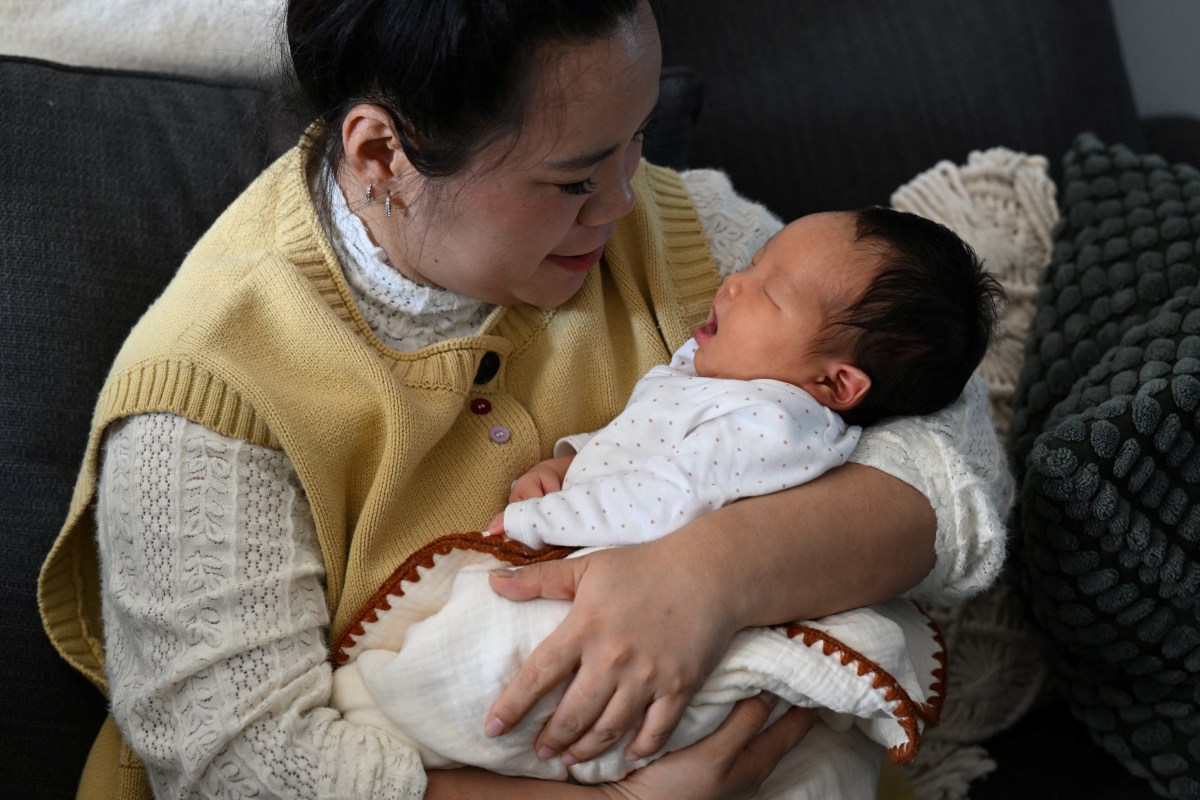 File photo: A woman looks at her newborn baby in Langfang in northern China's Hebei province on March 6, 2026.