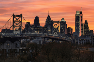 Horizonte da Filadélfia ao pôr do sol com os arranha-céus da Ponte Benjamin Franklin e do centro da cidade, a paisagem urbana da Pensilvânia e a vista do marco urbano. Exclusões de jogos de azar na Pensilvânia aumentam após negligência infantil