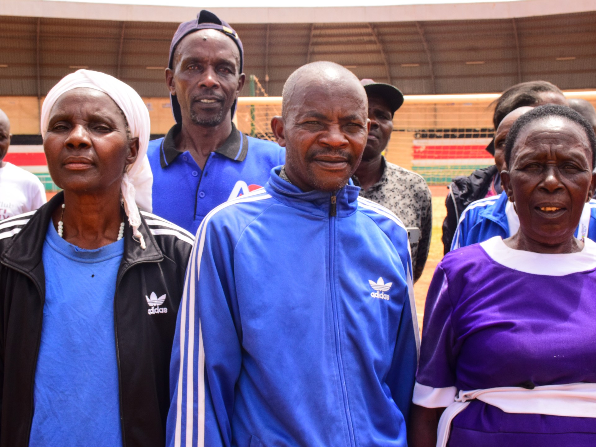 Atletas masters em Meru se alongam juntos antes de uma sessão matinal, transformando um campo empoeirado de uma vila em um campo de treinamento informal para idosos.