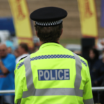 Policial da Grande Manchester em evento público enquanto as autoridades investigam suspeita de operação ilegal de jogos de azar no centro da cidade de Manchester