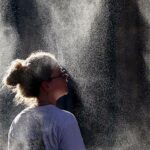 Uma mulher tira fotos de um termômetro marcando 40 graus Celsius em 21 de junho de 2026 em Sevilha, Espanha. Europa Ocidental eu