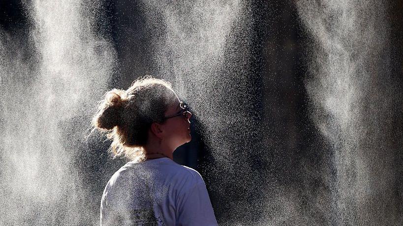 Uma mulher tira fotos de um termômetro marcando 40 graus Celsius em 21 de junho de 2026 em Sevilha, Espanha. Europa Ocidental eu