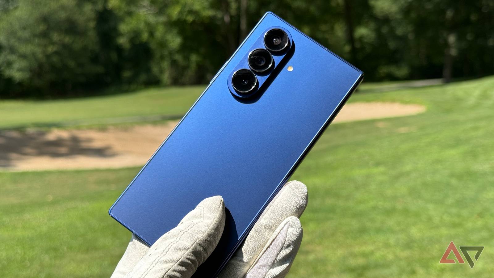 Samsung Galaxy Z Fold 7, com um dispositivo em pé e outro parcialmente dobrado, contra um fundo vermelho e bege