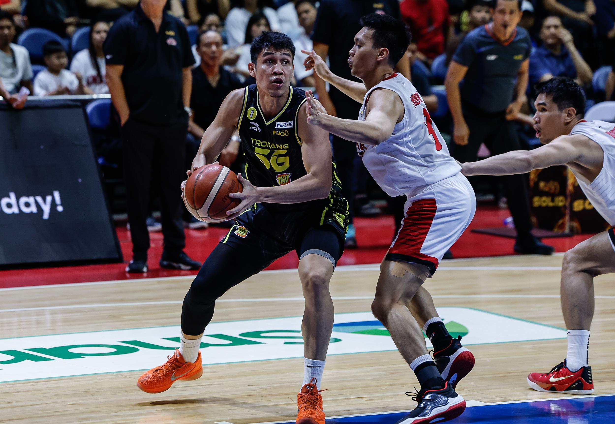 Calvin Oftana da TNT Tropang 5G durante um jogo contra Barangay Ginebra Gin Kings nas finais da PBA Commissioner's Cup.