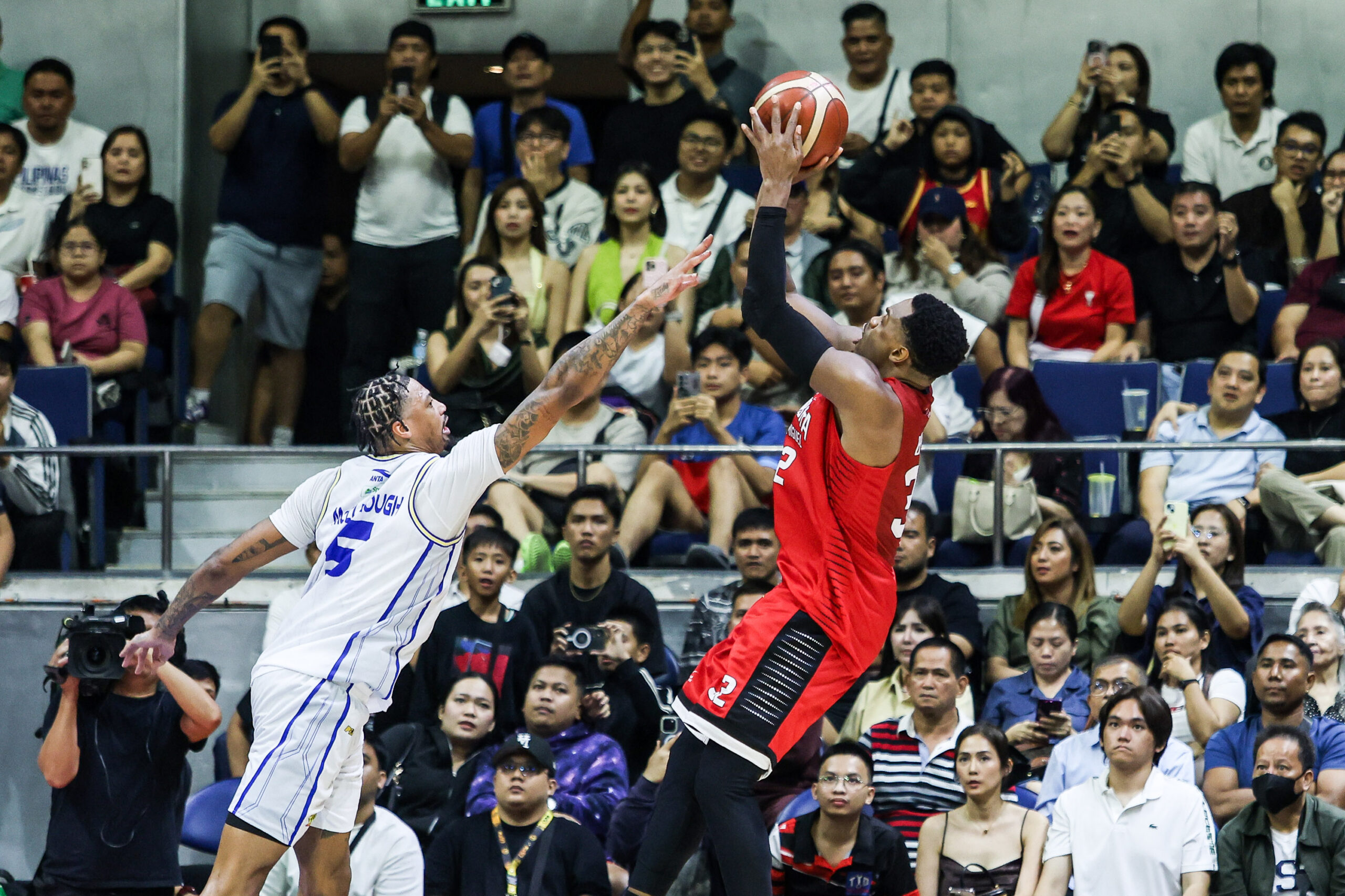 Justin Brownlee, do Barangay Ginebra Gin Kings, tenta um chute sobre Chris McCullough da TNT Tropang 5G durante o jogo 1 das finais da PBA Commissioner's Cup de 2026 entre Barangay Ginebra Gin Kings e TNT Tropang 5G.