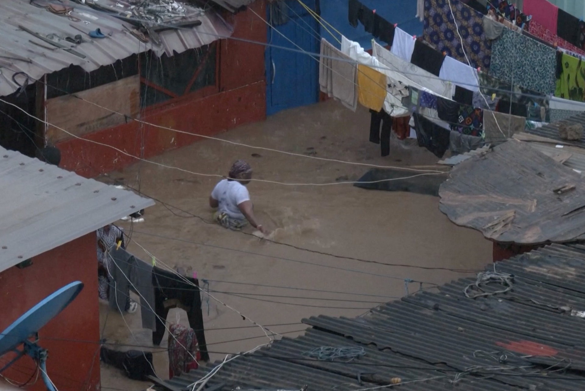 Pessoas atravessam enchentes, em Accra, Gana, nesta imagem tirada de um vídeo, 29 de junho de 2026. Reuters TV via REUTERS
