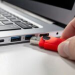 A USB flash drive stick and a laptop computer.