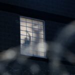 As part of a nightly tradition, imprisoned immigrants greet immigration activists from windows as ICE agents and pro-immigration activists face off outside the Delaney Hall Immigration Detention Center on May 27, 2026, in Newark, New Jersey.