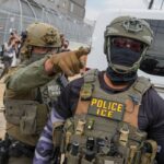 An ICE agent points toward protesters outside the detention center at Delaney Hall, in Newark, New Jersey, June 6, 2026.