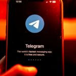 The logo for Telegram chat messenger application arranged on a smartphone.