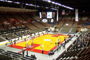 Vista interna de uma arena de basquete universitário durante um aquecimento de jogo, com quadra de madeira, placar, assentos para espectadores e fãs dentro do Fresno State Save Mart Center, na Califórnia. Investigação de apostas em Nevada leva à prisão em caso de basquete no estado de Fresno