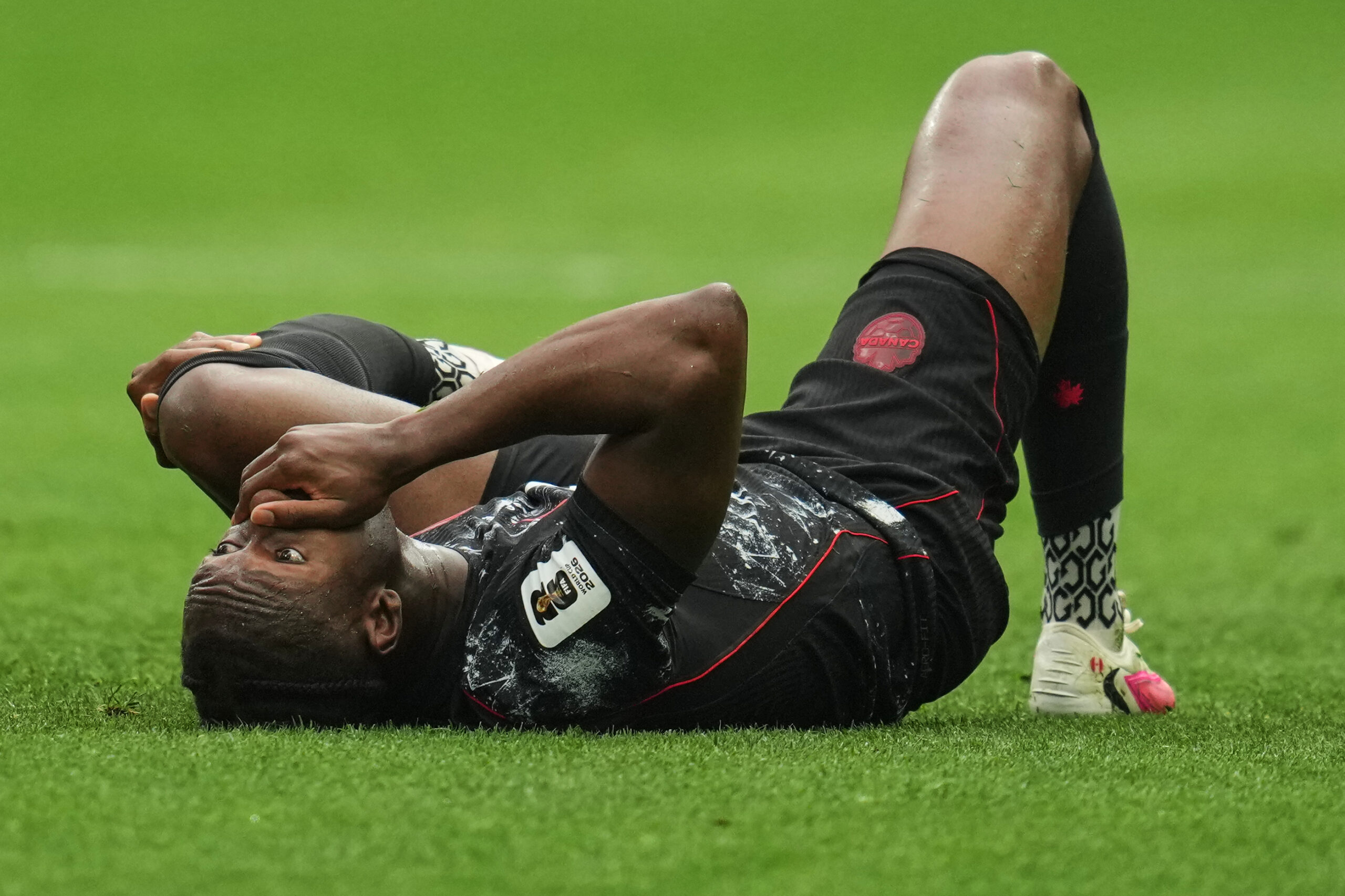 Ismael Kone, do Canadá, reage no chão após sofrer uma lesão durante a partida de futebol do Grupo B da Copa do Mundo contra o Catar, em Vancouver, Colúmbia Britânica, quinta-feira, 18 de junho de 2026.