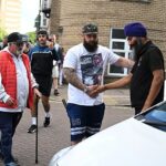 O taxista sikh Kulwinder Singh, 47, aperta a mão de um manifestante em Southampton na noite passada