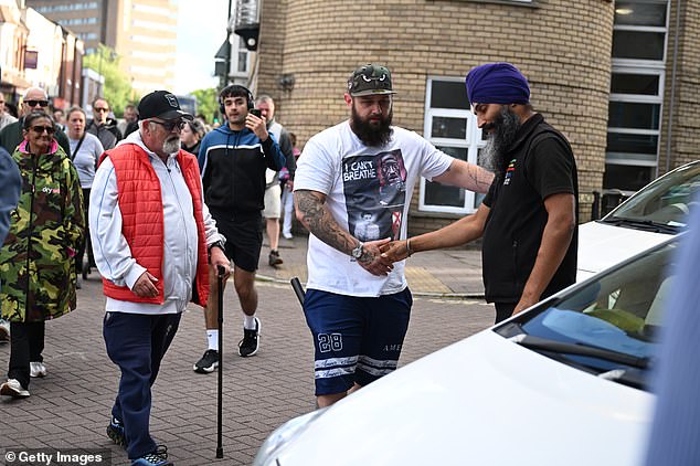 O taxista sikh Kulwinder Singh, 47, aperta a mão de um manifestante em Southampton na noite passada