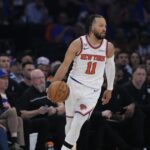 O atacante do New York Knicks, Og ​​Anunoby (8), tenta chutar sobre o atacante do San Antonio Spurs, Victor Wembanyama (1), durante a primeira metade do jogo 4 da série de basquete das finais da NBA, quarta-feira, 10 de junho de 2026, em Nova York. (Foto AP/Frank Franklin II)