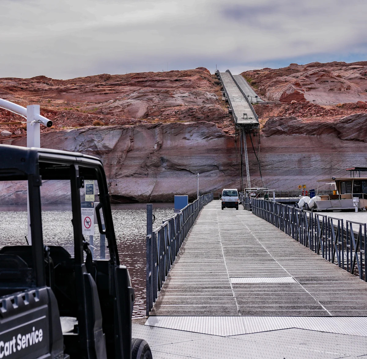Os baixos níveis de água no Lago Powell são aparentes nesta imagem de fevereiro de 2026 que mostra o final de uma doca flutuante pendurada em um penhasco em Antelope Marina em Page, Arizona. Os trabalhadores abriram um novo caminho para a água através da rocha sólida.