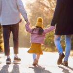 Stock image/file photo: Parents walking hand in hand with child.