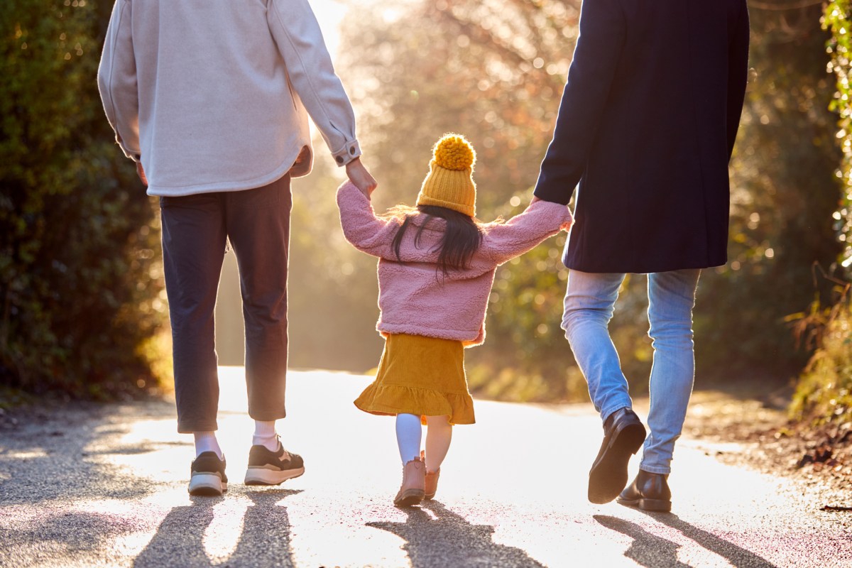 Stock image/file photo: Parents walking hand in hand with child.