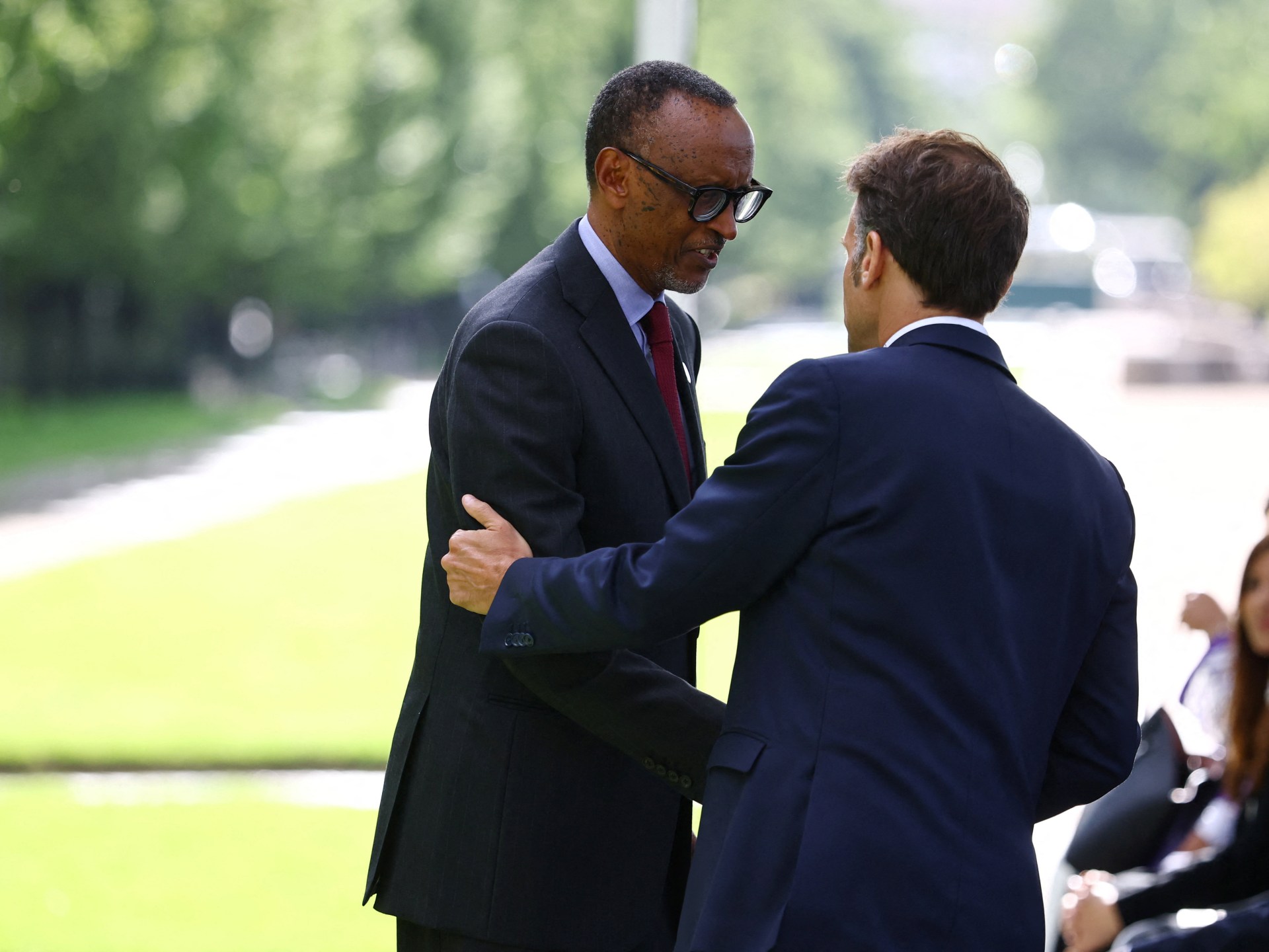 (Da esquerda) O presidente do Ruanda, Paul Kagame, a primeira-dama do Ruanda, Jeannette Kagame, e o presidente da França, Emmanuel Macron, de pé após depositarem coroas de flores num monumento em homenagem às vítimas do genocídio do Ruanda, feito pela artista portuguesa Grada Kilomba, durante uma cerimónia na Esplanada Habib-Bourguiba, ao longo do rio Sena, em Paris, a 2 de junho de 2026. (Foto de Sarah Meyssonnier / POOL / AFP) / RESTRITO A USO EDITORIAL - MENÇÃO OBRIGATÓRIA DO ARTISTA NO MOMENTO DA PUBLICAÇÃO - PARA ILUSTRAR O EVENTO CONFORME ESPECIFICADO NA LEGENDA