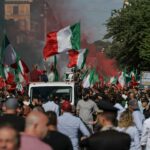 As pessoas seguram um banner na leitura italiana