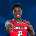 Jogador de basquete do Dayton Flyers com camisa vermelha nº 2 apontando para a câmera durante o retrato oficial do time. NCAA proíbe permanentemente Adam Njie após caso de compartilhamento de informações de apostas