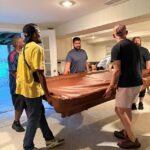 Membros da equipe de suporte da Inglaterra retiram a mesa de sinuca após adquiri-la no Facebook Marketplace