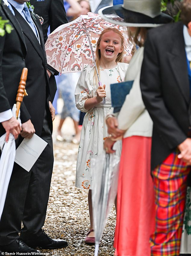 Lena Tindall manteve seu título de realeza mais brincalhona no casamento real de Peter Phillips e Harriet Sperling hoje, enquanto ela brincava alegremente na chuva enquanto segurava um guarda-chuva de unicórnio
