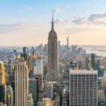 Vista panorâmica do horizonte da cidade de Nova York com o Empire State Building e os arranha-céus de Lower Manhattan durante o pôr do sol, destacando o centro financeiro e de entretenimento de Nova York. Nova York avança projeto de lei que exige extratos mensais de contas de apostas esportivas