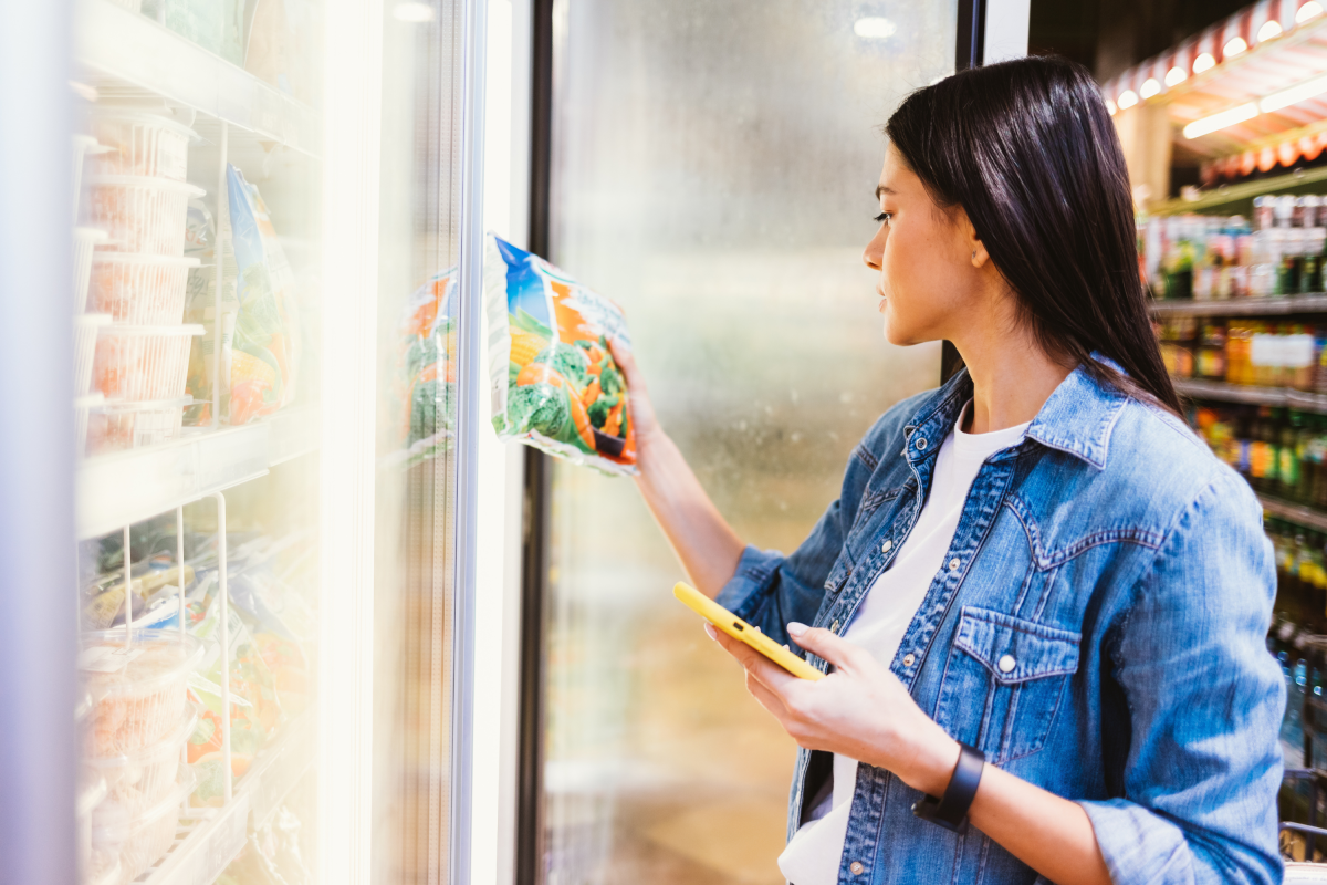 Stock photo: Young brunette woman buying fresh frozen food in the store.